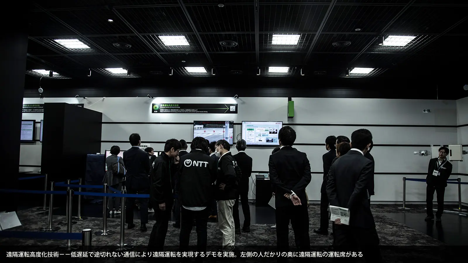 遠隔運転高度化技術−−低遅延で途切れない通信により遠隔運転を実現するデモを実施。左側の人だかりの奥に遠隔運転の運転席がある